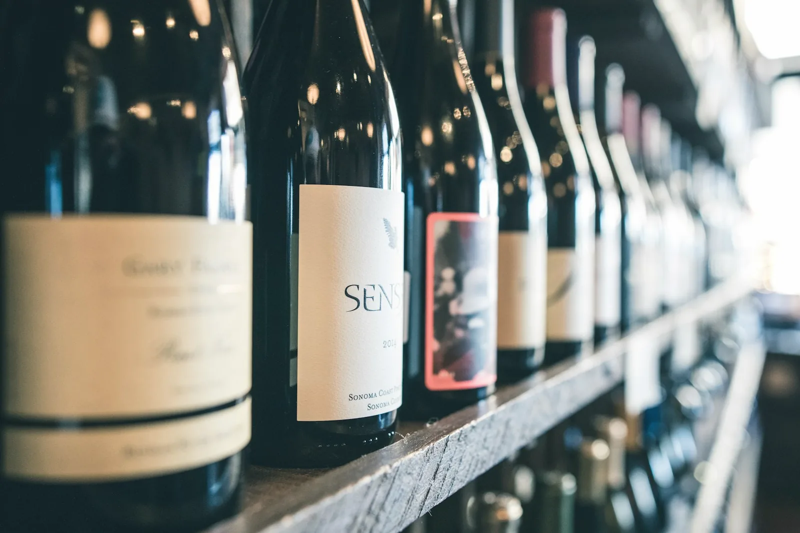 Des bouteilles de vin alignées sur une étagère en bois