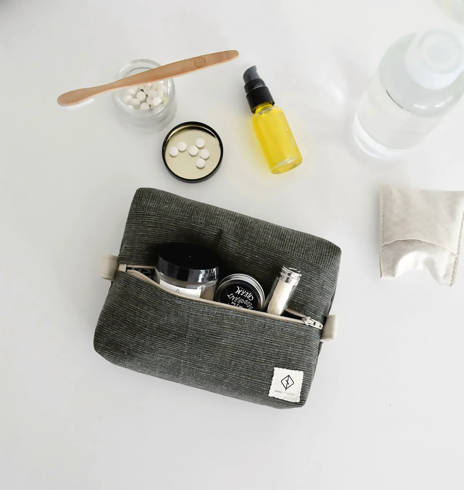 Une trousse de toilette avec brosse à dents en bois et soins, vue de dessus