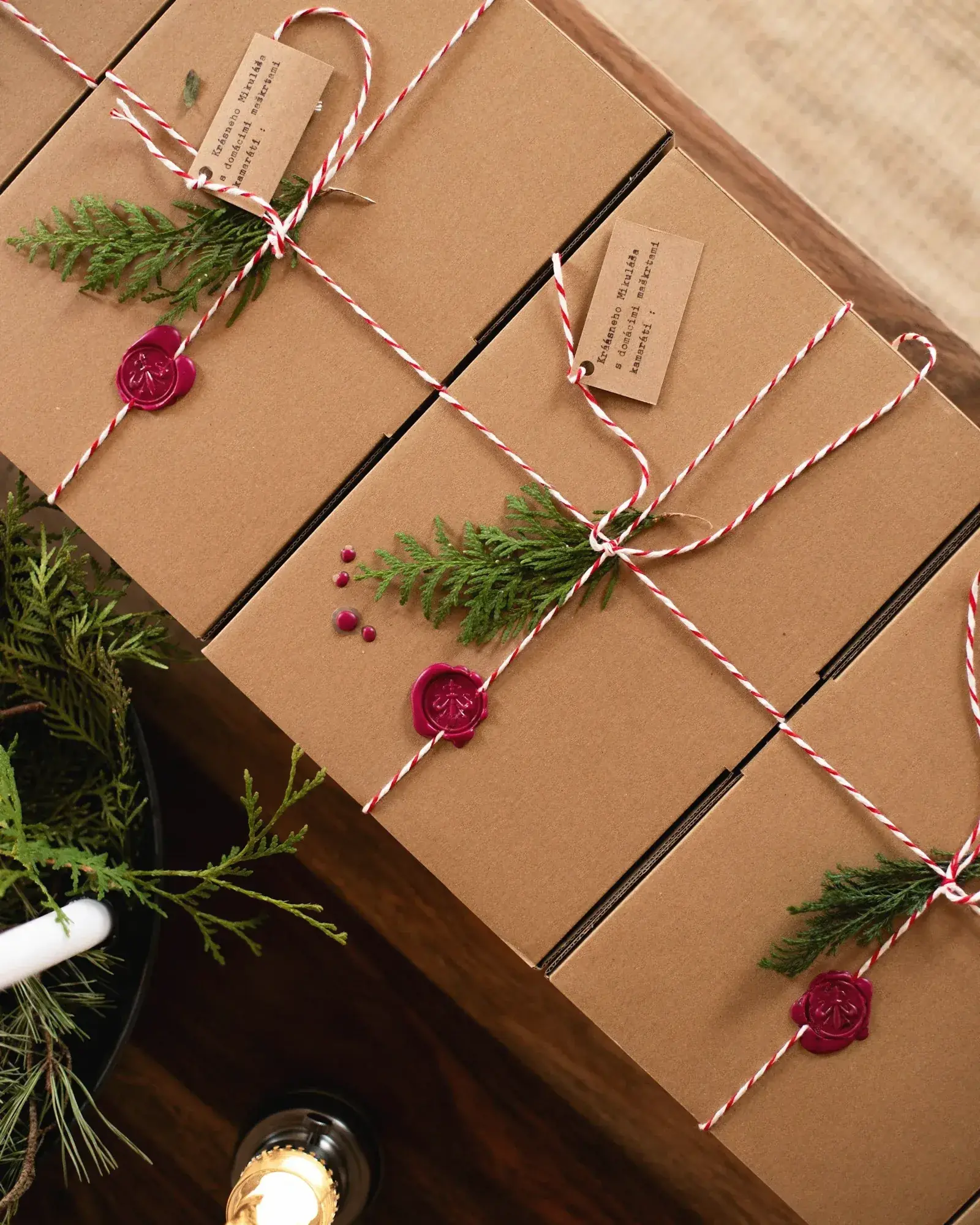 Des coffrets cadeaux en papier kraft, noués de ficelle rouge et blanche
