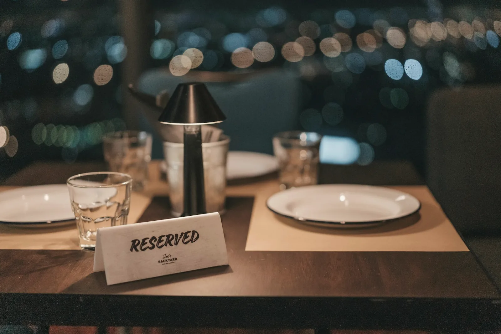 Une table réservée dans un restaurant, devant les lumières de la ville
